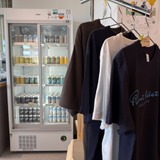 持ち帰り用の缶が並ぶ冷蔵ケースとオリジナルグッズ